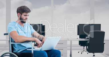 Man sitting in wheelchair and using laptop