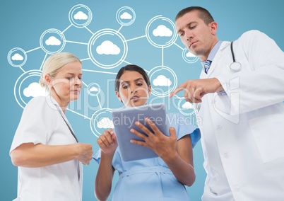 Male and female doctors discussing over digital tablet with cloud computing icons in background