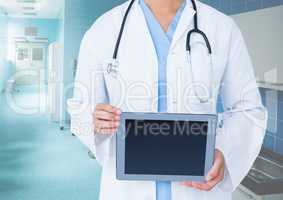 Doctor holding a digital tablet in corridor at hospital