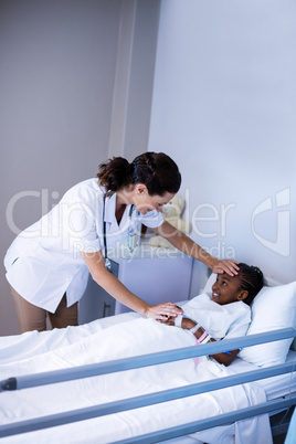 Female doctor checking patient fever in ward