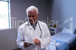 Male doctor using digital tablet in ward