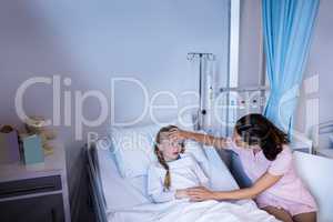 Female doctor checking patient fever in ward