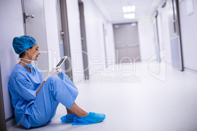 Surgeon sitting on floor and using digital tablet