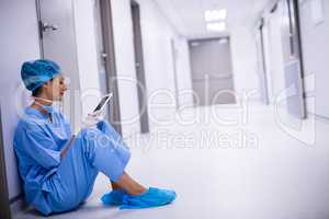 Surgeon sitting on floor and using digital tablet