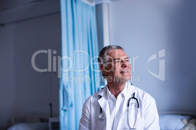 Thoughtful doctor sitting in ward