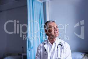 Thoughtful doctor sitting in ward