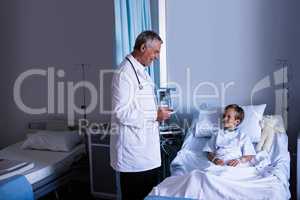 Male doctor interacting with patient during visit in ward