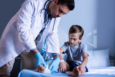 Male doctor examining patient leg