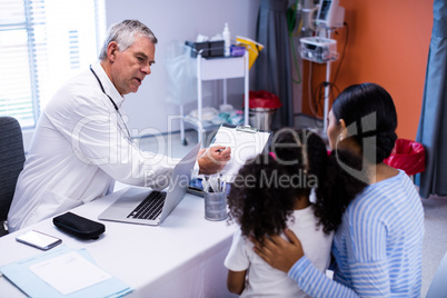 Doctor and patient discussing over clipboard