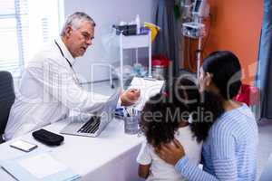 Doctor and patient discussing over clipboard