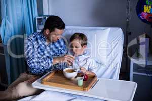 Father feeding breakfast to his son