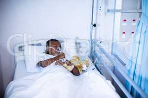 Patient sleeping with teddy bear on the bed at hospital