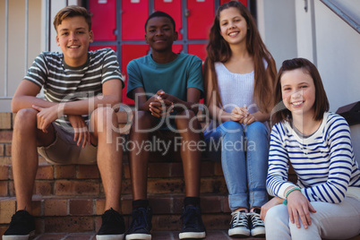 Portrait of students sitting on staircase