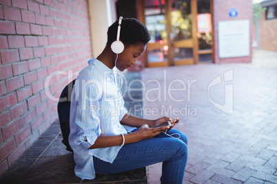 Schoolgirl listening music on mobile phone