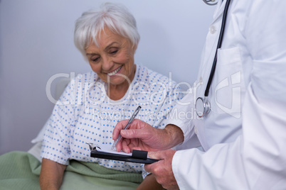 Doctor discussing medical report with senior patient