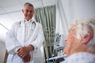 Doctor interacting with senior patient in ward