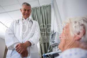 Doctor interacting with senior patient in ward