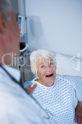 Doctor interacting with senior patient in ward