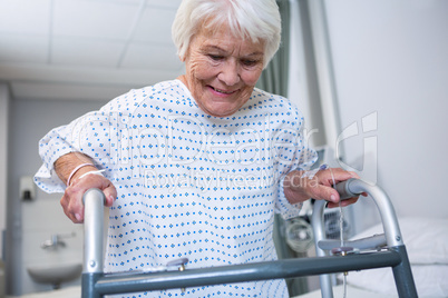 Smiling senior patient holding walking frame