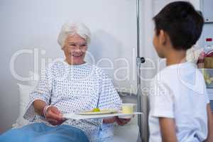 Senior patient holding tray of breakfast