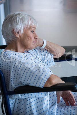 Disabled senior patient on wheelchair in hospital passageway