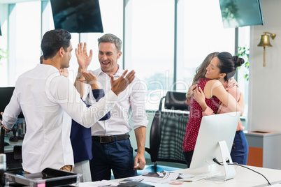 Business colleagues embracing and celebrating in the office Business colleagues embracing and celebrating in the office