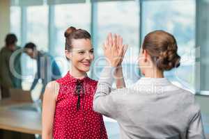 Business executives giving high five to each other