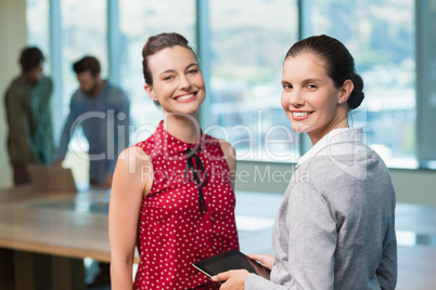 Business executives smiling while standing in office