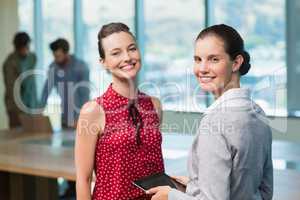 Business executives smiling while standing in office