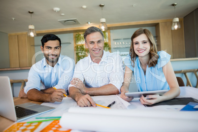 Smiling architects sitting together in conference room