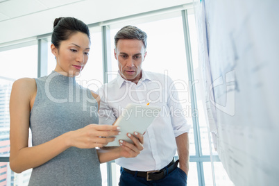 Architects discussing over digital tablet in conference room