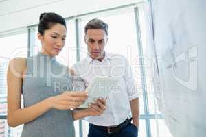 Architects discussing over digital tablet in conference room