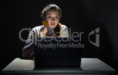 Woman watching movie and eating cracker