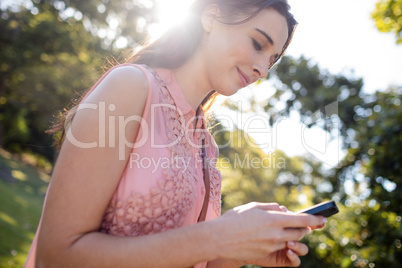 Beautiful woman using her mobile phone in the park