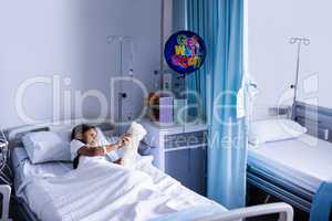 Patient relaxing on bed with teddy bear