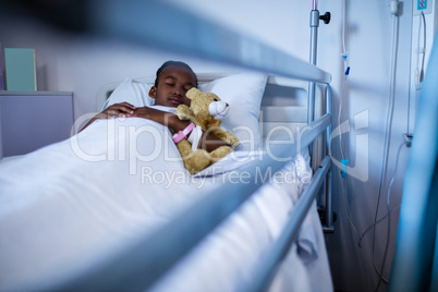 Patient sleeping with teddy bear on the bed