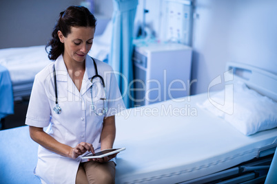 Female doctor using digital tablet in ward