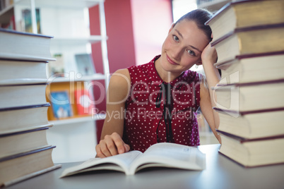 Attentive schoolgirl studying in library