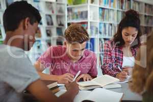 Attentive classmates studying in library