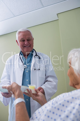 Doctor serving breakfast and medicine to senior patient