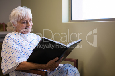 Happy senior patient reading book