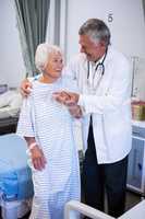 Doctor assisting senior patient in ward