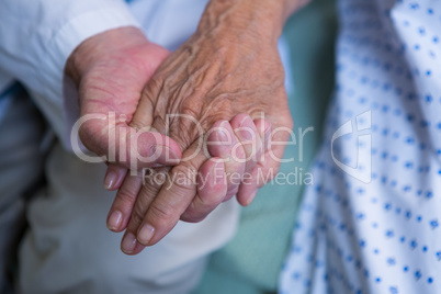 Doctor consoling senior patient in hospital