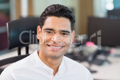Smiling business executive sitting on chair in office