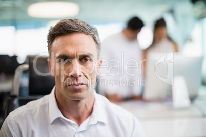 Portrait of serious business executive sitting on chair