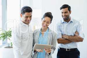 Business colleagues discussing over digital tablet in office