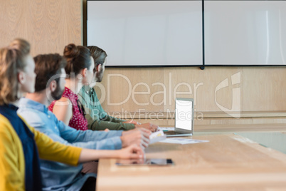 Business executives listening to a presentation in conference room