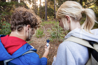 Rear view of hiking couple checking the compass