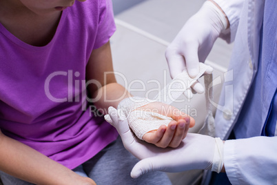 Doctor putting bandage on injured hand of patient