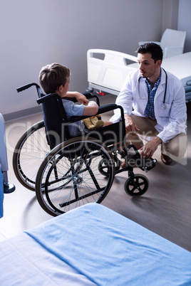 Male doctor interacting with child patient in ward